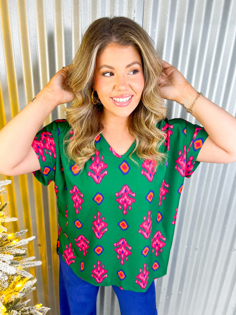Green short sleeve top with hot pink print. 